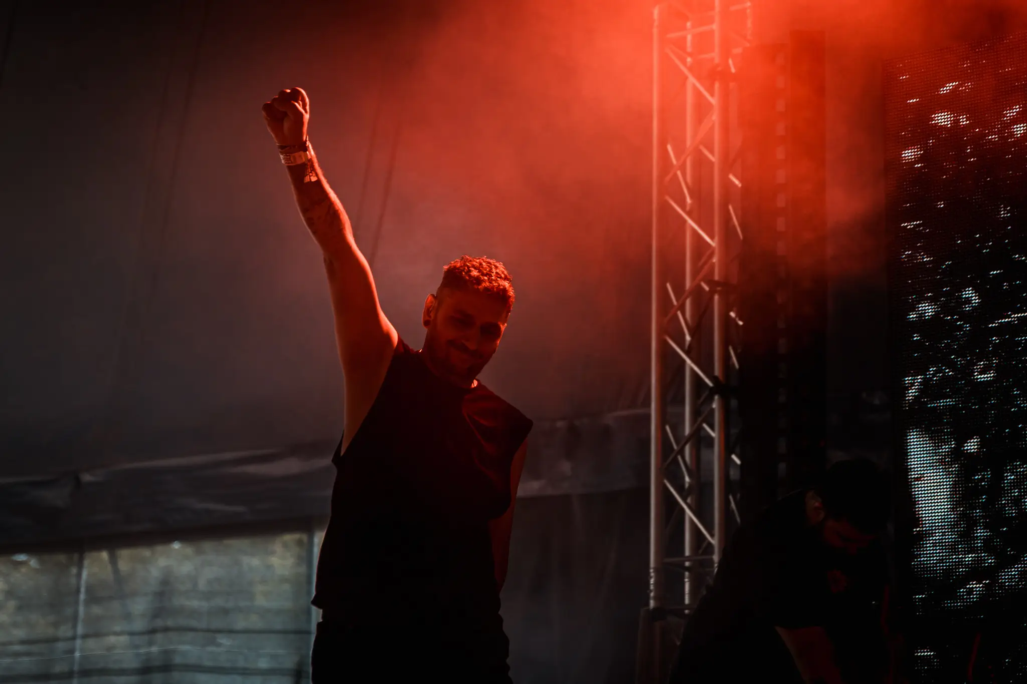 Silhouette of the guitarist with a raised fist in red light