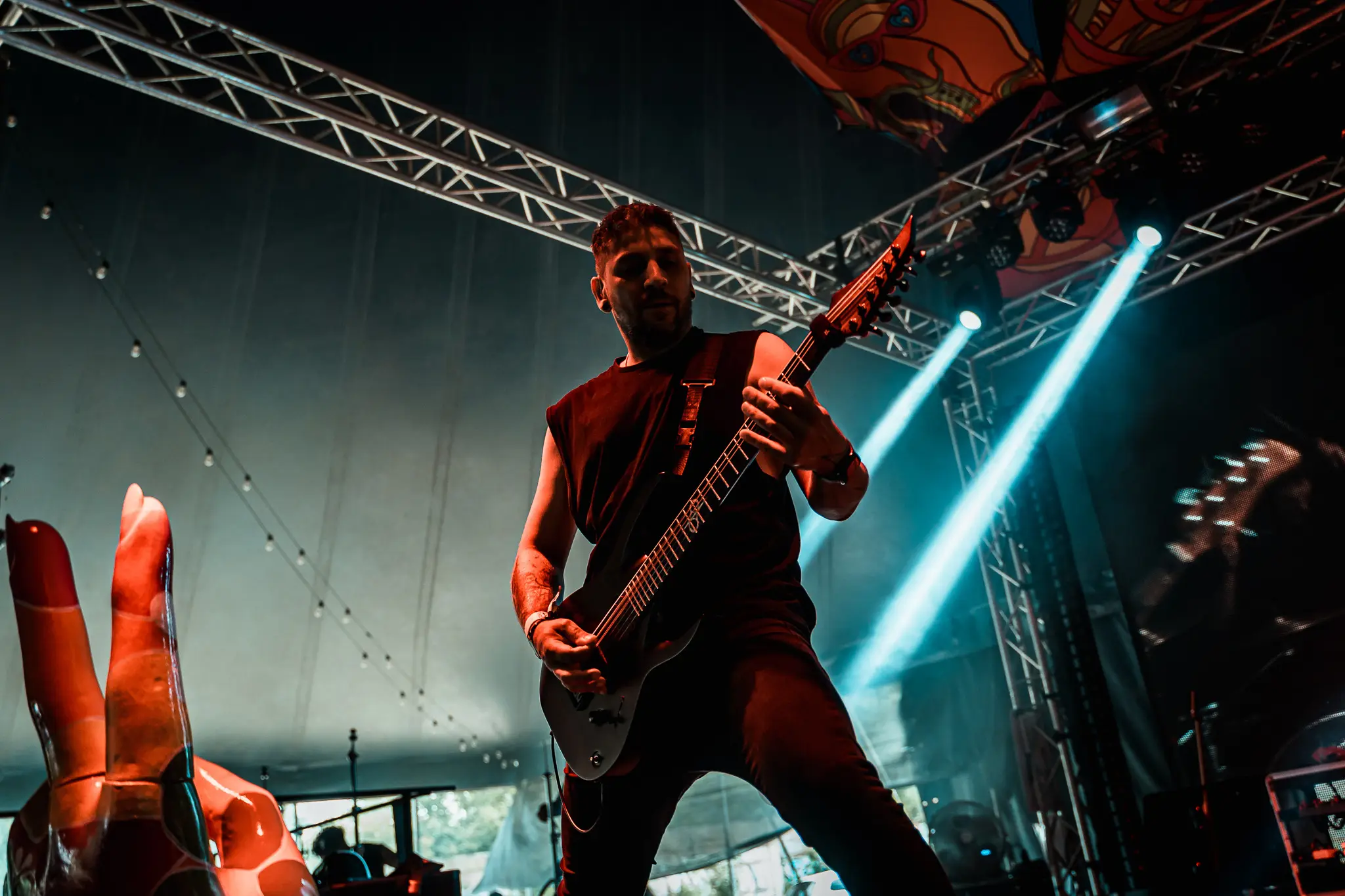 Guitarist mid-riff with light beams cutting through haze