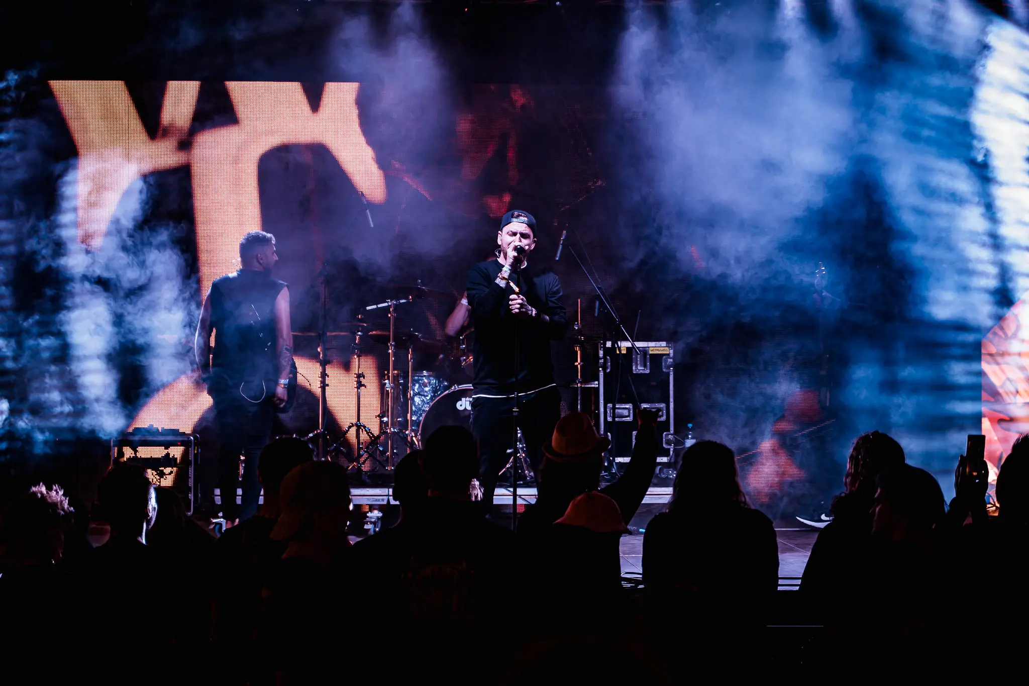 The band on stage in blue haze under a giant WTG backdrop, Rock for People 2025