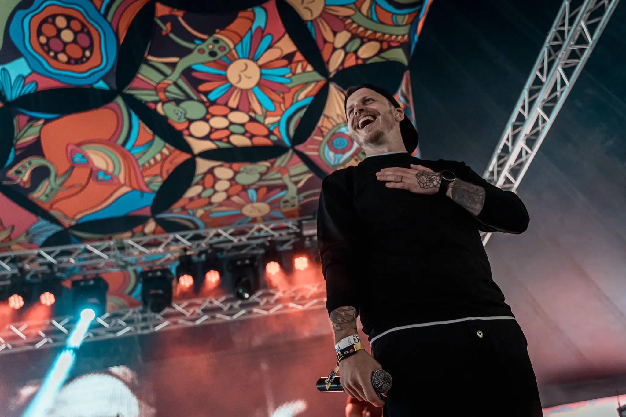 Vocalist laughing under the painted tent roof, Rock for People 2025
