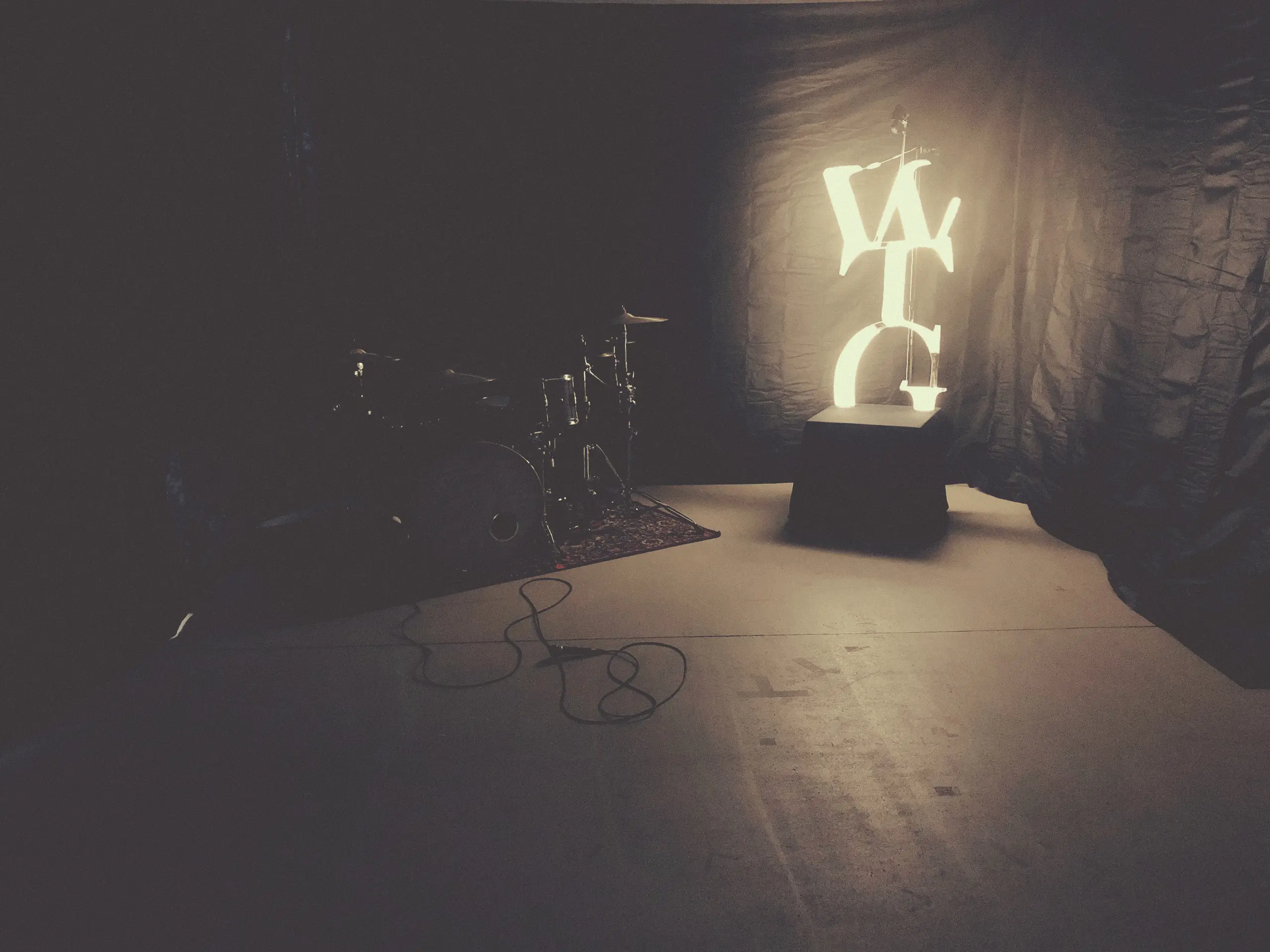 Empty stage with a glowing WTG sign next to the drum kit